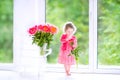 Toddler girl playing with peony flowers Royalty Free Stock Photo