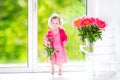 Toddler girl playing with peony flowers Royalty Free Stock Photo