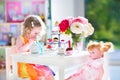Toddler girl playing tea party with a doll Royalty Free Stock Photo