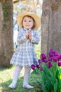 Toddler girl playing with tulips outside Royalty Free Stock Photo