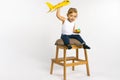 Toddler girl sitting on and posing with a yellow plane toy. Gender stereotypes