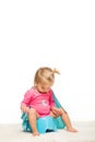 adorable toddler girl in superhero cape sitting on pottie