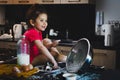 Toddler girl smiling while grab chocolate in a mesy table