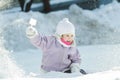 Toddler girl tossing up natural snow with plastic