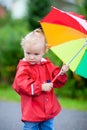 Toddler girl with umbrella outdoors on rainy day Royalty Free Stock Photo