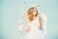 Toddler girl wearing angel costume white dress and feather wings. Cherub girl. Pretty teen girl. little Cupid girl