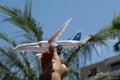 Toddler hand holding an airplane toy with clear sky and blurred building and plants as a background Royalty Free Stock Photo