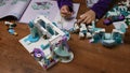 Toddler hands takes tiny Lego snowman and put in a row while playing Lego blocks of Frozen Disney cartoon