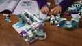 Toddler hands takes tiny Lego snowman and put in a row while playing Lego blocks of Frozen Disney cartoon