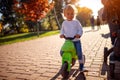 Toddler having fun on bikes in autumn park