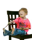 Toddler having fun sitting painting herself