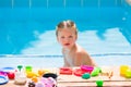 Toddler kid girl playing food toys in swimming pool Royalty Free Stock Photo