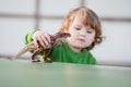 Toddler kid playing with a toy dinosaur Royalty Free Stock Photo