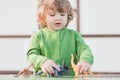 Toddler kid playing with a toy dinosaur Royalty Free Stock Photo