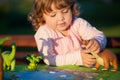 Toddler kid playing with a toy dinosaur.