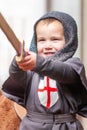 Toddler in knight costume with big smile playing with sword. Royalty Free Stock Photo