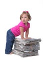 Toddler leaning against stacks of newspaper