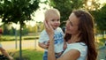 Toddler with mother standing on street. Smiling woman holding boy on hands Royalty Free Stock Photo