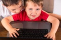 Toddler and older brother having fun on laptop