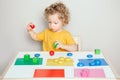 Toddler playing with learning toys at home or kindergarten. Baby sorting organising objects blocks with specific color. Early age