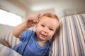 Toddler, playing and portrait of baby on couch in home for fun crawling or learning in living room. Happy, boy or face Royalty Free Stock Photo