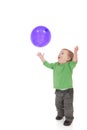 Toddler playing with purple balloon