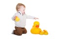 A toddler playing with rubber ducks