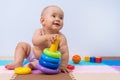 A toddler plays with a multi-colored pyramid of rings. Development of thinking and hand motor skills Royalty Free Stock Photo