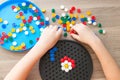 A toddler plays with a plastic mosaic on the carpet in the children`s room. Early development
