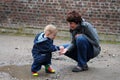 Toddler plays in a puddle