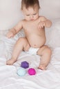 A toddler plays with rubber balls to develop motor skills and tactile sensations Royalty Free Stock Photo