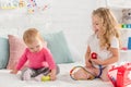 toddler and preschooler sisters playing with first aid kit