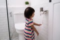 Toddler pulling out toilet paper Royalty Free Stock Photo