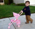 Toddler pushing pram Royalty Free Stock Photo