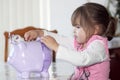 Toddler Putting Money in Savings