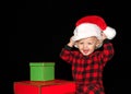 Toddler putting on a santa hat with christmas presents Royalty Free Stock Photo