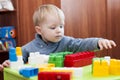 Toddler reaching for a toy constuctor indoor Royalty Free Stock Photo