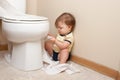 Toddler ripping up toilet paper Royalty Free Stock Photo