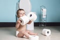 Toddler ripping up toilet paper in bathroom