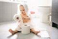 Toddler ripping up toilet paper in bathroom Royalty Free Stock Photo