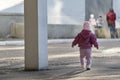 Toddler runs to the children. Little girl walking on the street. Child abandoned on street and walks alone