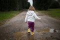 Toddler splashing in puddle in country road Royalty Free Stock Photo