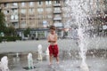 Toddler and a splashing water fountain Royalty Free Stock Photo