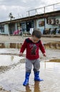 Toddler standing in a puddle with his new boots Royalty Free Stock Photo