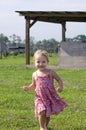 Toddler in sundress running on farm Royalty Free Stock Photo