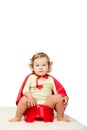 toddler in superhero cape sitting on pottie