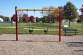 Toddler swings in a community playground with colorful posts and a wood chip ground