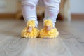 toddler taking first steps in duckling slippers Royalty Free Stock Photo