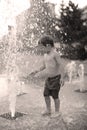 Toddler walking in a splashing water fountain Royalty Free Stock Photo