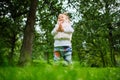 The toddler walks in the summer park and claps his hands Royalty Free Stock Photo